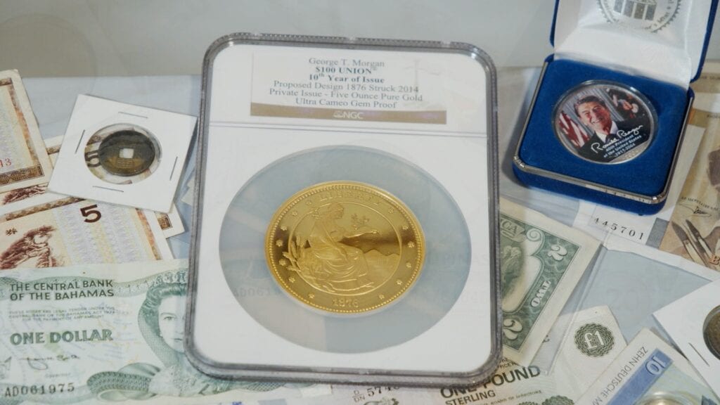 A gold coin sitting on top of some money.